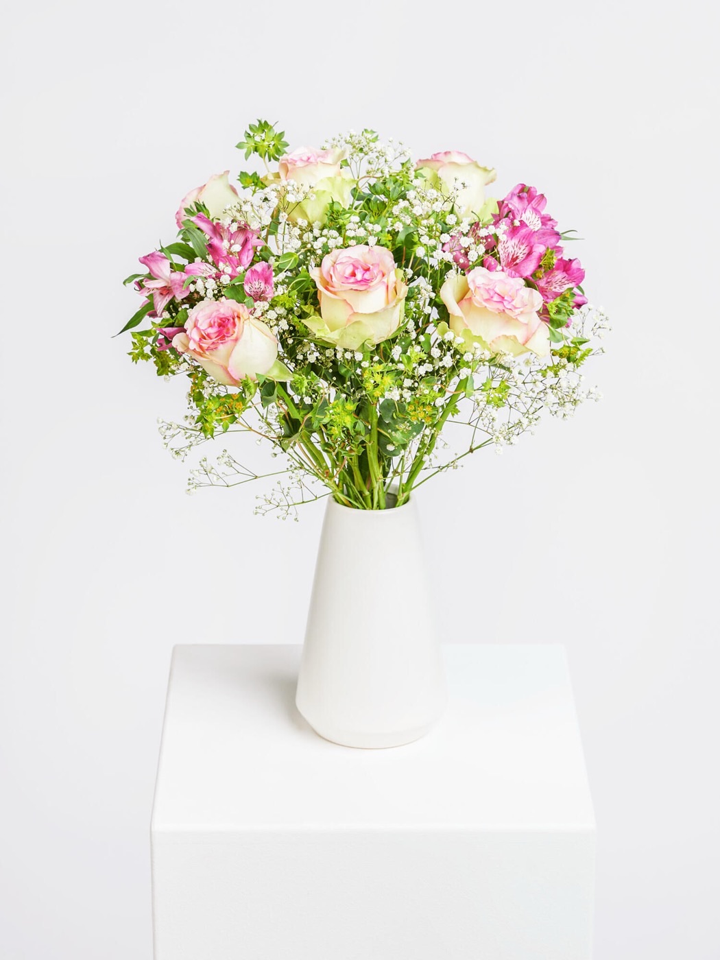Handgebundener Strauß aus Rosen und Alstroemeria in einer weißen Vase